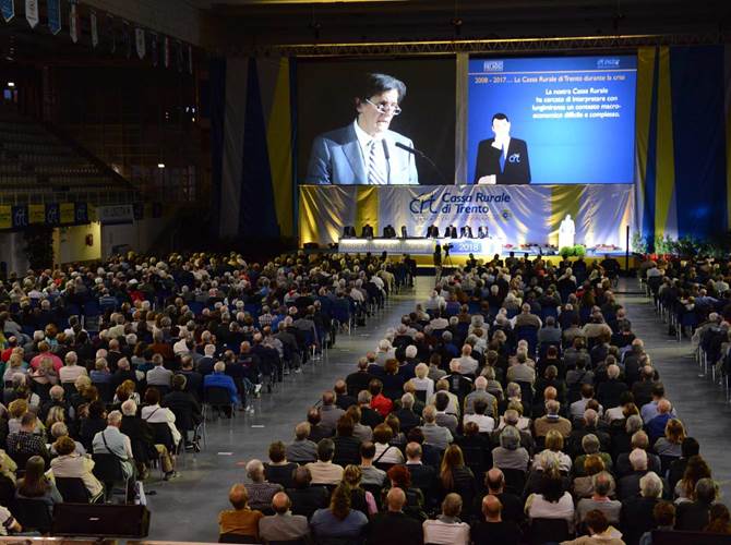Cassa Rurale di Trento, un valore per il territorio. Confermato il presidente Giorgio Fracalossi Assemblea dei soci al Palazzetto dello Sport, alla presenza di 2.120 soci (più 183 deleghe).  Cresce la raccolta, ancora in flessione la domanda di credito. Utile a 4,1 milioni, margine di intermediazione di  53,6 milioni. Bilancio approvato all’unanimità.175,5 milioni di patrimonio, indice di solidità Cet1 di 15,86%. I soci sono 18mila, 631  i nuovi entrati nel 2017. In dieci anni 23 milioni distribuiti ai soci: un valore per il territorio.Il presidente Fracalossi: “Le banche sono radicalmente cambiate, in futuro l’innovazione tecnologica sarà sempre più importante, ma non mancherà mai la relazione diretta con le persone. Il progetto di riforma cambierà il credito cooperativo, ma al centro del sistema ci sono e resteranno le Casse Rurali. La scelta di Cassa Centrale, orgoglio per il Trentino”.Giorgio Fracalossi confermato alla presidenza. In cda entrano la commercialista Saveria Moncher e l’avvocato Paolo Toniolatti, confermata Mariangela Sandri. Confermato il collegio sindacale uscente.